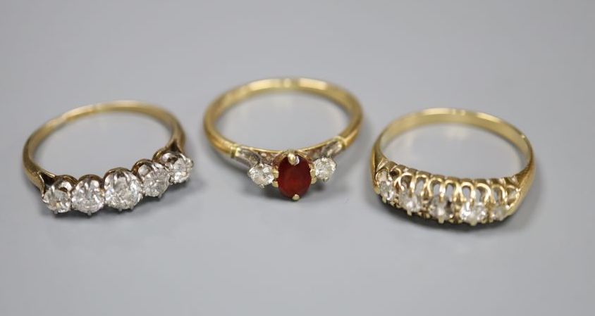 An 18ct gold, garnet? and diamond three stone ring and two yellow metal and five stone diamond half hoop rings, gross 8.4 grams.